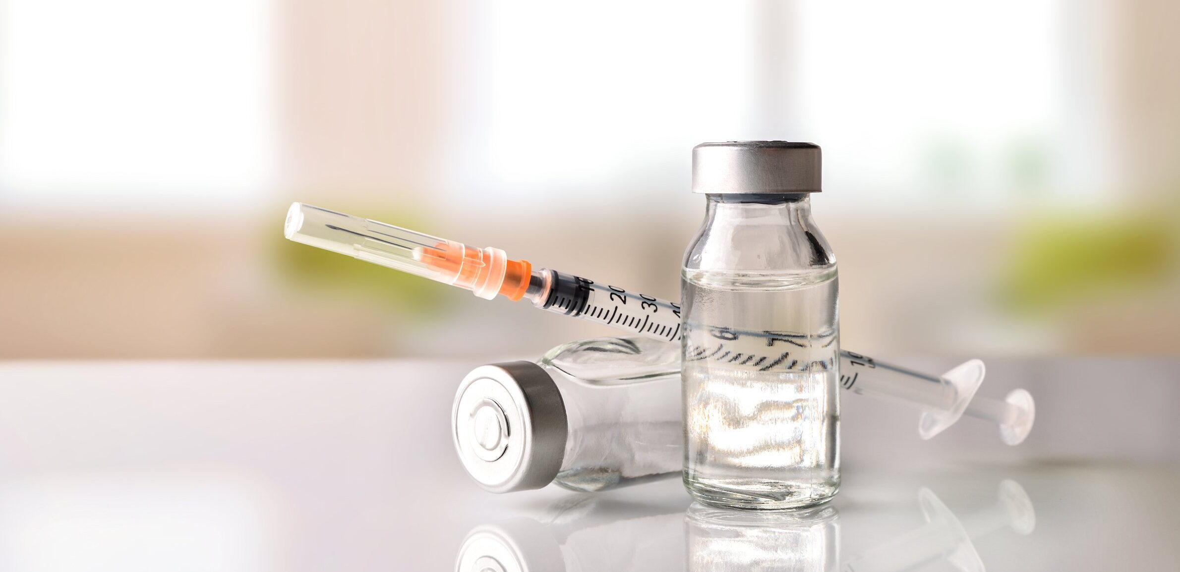 Vials,With,Medication,And,Syringe,On,White,Methacrylate,Table,With